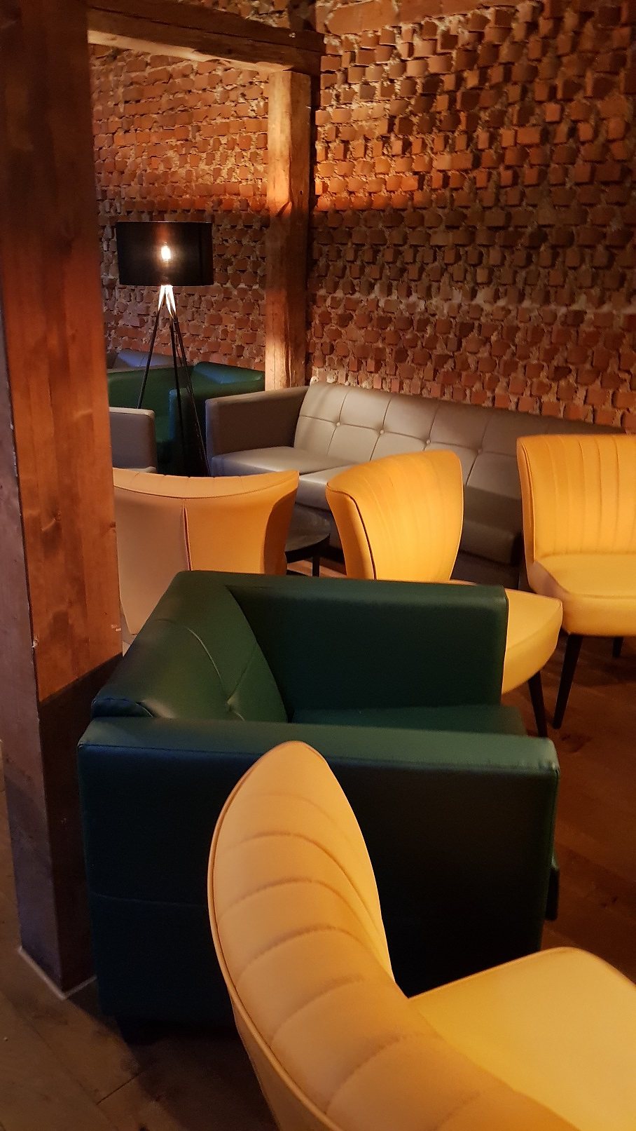 Lounge der Bar N°1 mit Ledersesseln vor historischer Backsteinwand